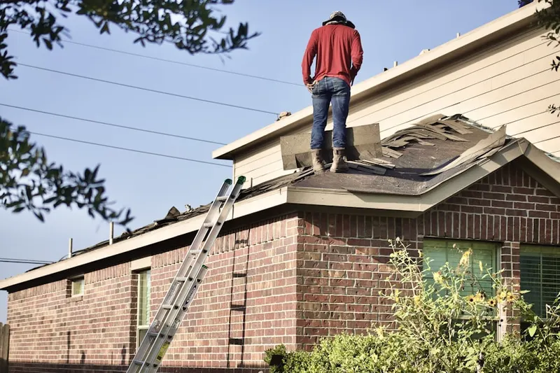 Professional roofer working on a residential roof in Brookhollow